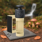 Schwarzes 7-Kilogramm-Gewicht auf beigem Halter mit der Aufschrift FORGELEVEL auf grauer Steinplatte im Wald mit Pilzen und Herbstlaub