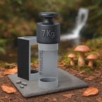 Schwarzes 7-Kilogramm-Gewicht auf grauem Halter mit der Aufschrift FORGELEVEL auf grauer Steinplatte im Wald mit Pilzen und Herbstlaub