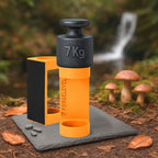 Schwarzes 7-Kilogramm-Gewicht auf orangenem Halter mit der Aufschrift FORGELEVEL auf grauer Steinplatte im Wald mit Pilzen und Herbstlaub